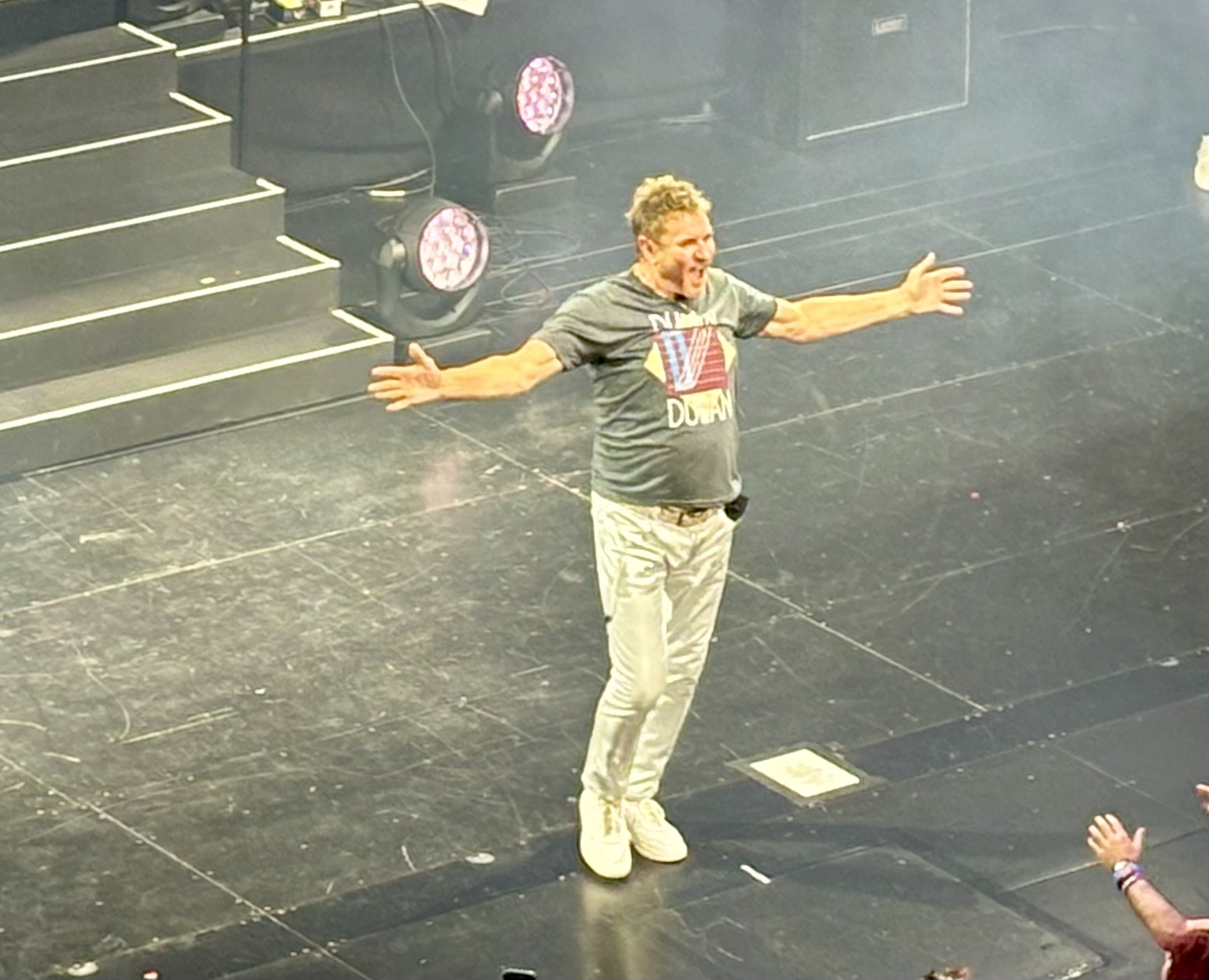 SImon Le bon, center stage, arms outstretch, wearing a duran duran tshirt