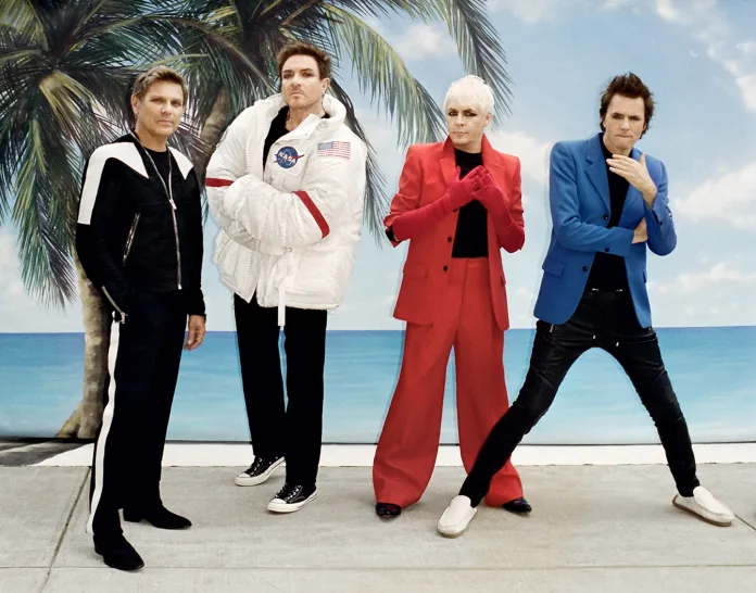 From left: Roger Taylor wears his own Jacket, T-Shirt by Calvin Klein, Pants by Alexander McQueen, Shoes by Saint Laurent by Anthony Vaccarello. Simon Le Bon wears Coat and Pants by Balenciaga, T-Shirt by Calvin Klein. Nick Rhodes wears Coat and Pants by AMI, Tank Top by Calvin Klein, and John Taylor wears Jacket by AMI and Sweater by Judy Turner.